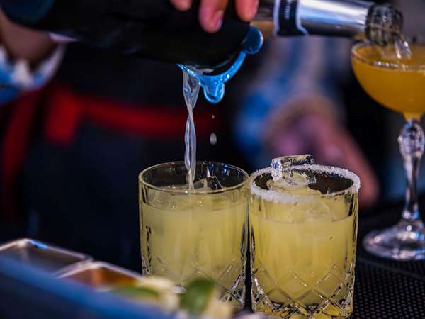 Margaritas being poured from a cocktail shaker