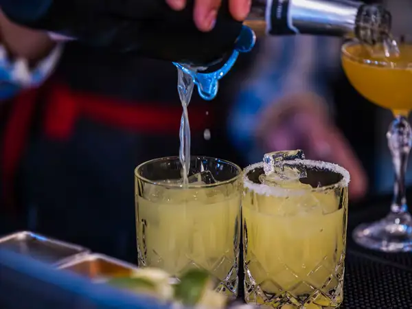 Margaritas being poured from a cocktail shaker